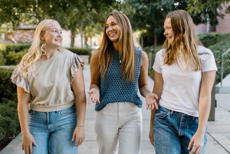 3 female friends laughing and walking 